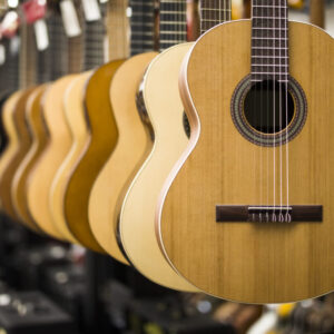 Close up view at acoustic guitars in row in music shop